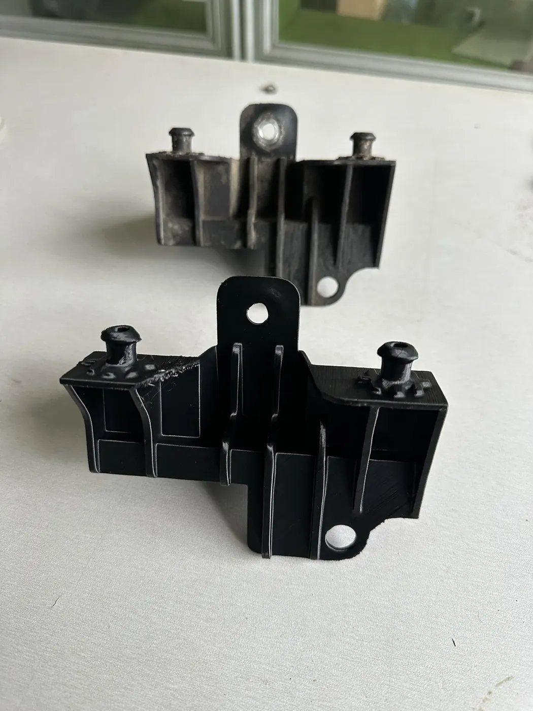Arkada yıpranmış orijinal braket, önde aynı formda yeni 3D baskı braket